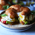 Croissant and fried egg sandwich with avocado and grilled pineapple