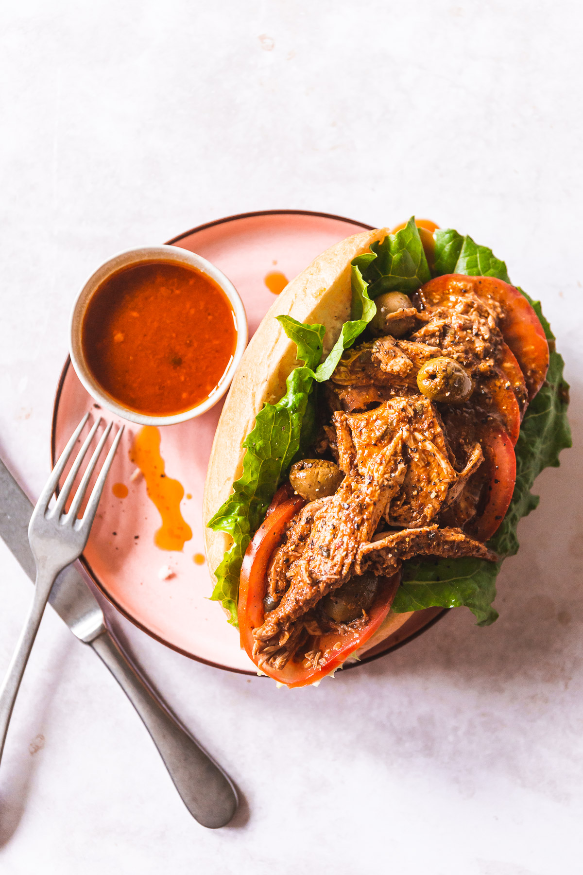 a bolillo roll filled with romaine lettuce, sliced tomatoes and salvadoran turkey