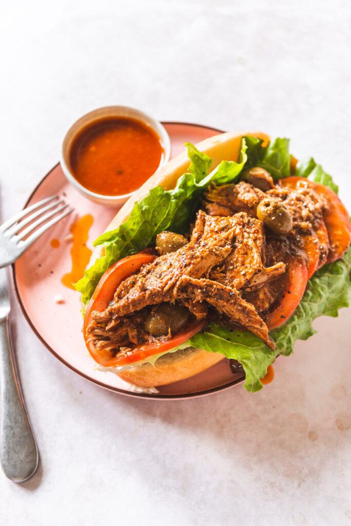 a bolillo roll filled with romaine lettuce, sliced tomatoes and salvadoran turkey