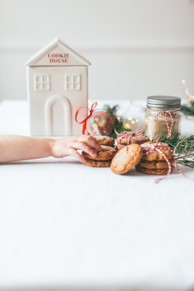 overhead of cookies, some tied up in red and white string with a little hand reaching in