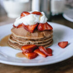 pancake stack with strawberries and whipped cream