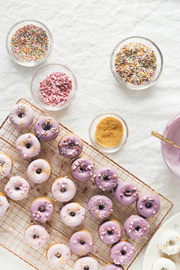 Over head shot of Baked Buttermilk Frosted Mini Donuts as well as the sprinkle ingredients.  