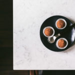 Overhead image of a table and chairs with a small black plate holding 3 truffles