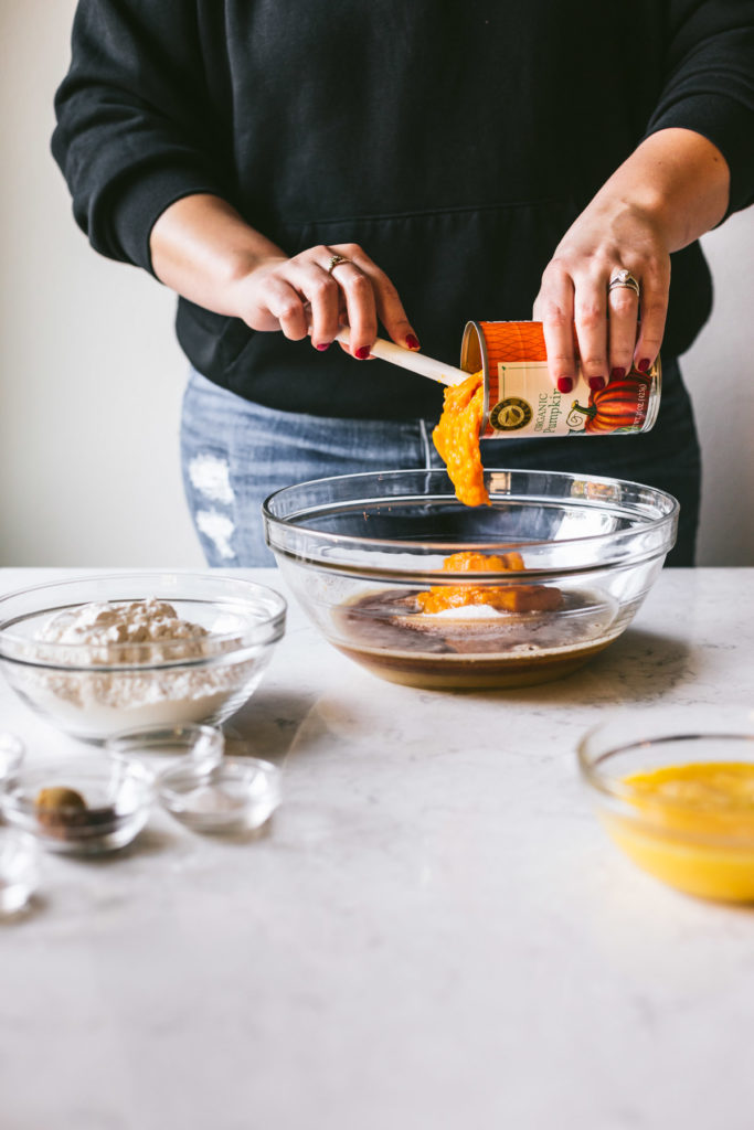 Pumpkin head on image of Karlee pouring pumpkin pure' into a glass bowl with Browned Butter Cream Cheese Frosting