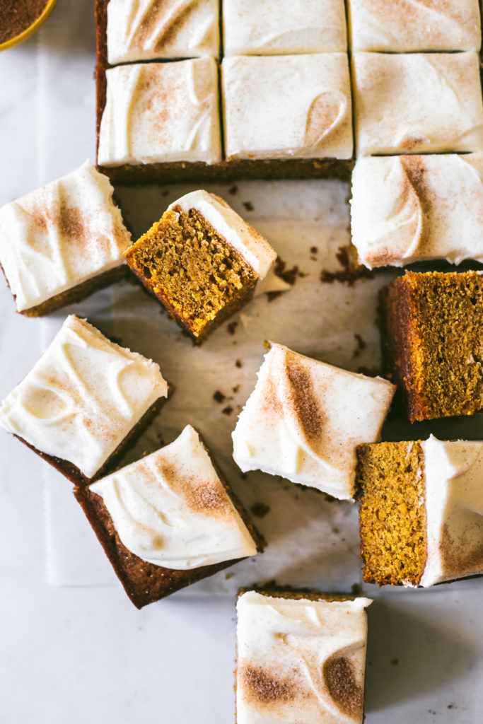 Pumpkin Bars with Browned Butter Cream Cheese Frosting sprinkled with cinnamon and sugar and cut into squares