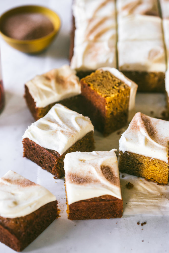 Pumpkin Bars with Browned Butter Cream Cheese Frosting sprinkled with cinnamon and sugar and cut into squares