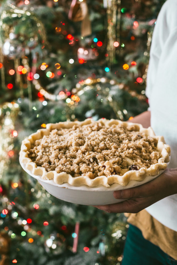 Finished pie being held in front of a Christmas tree