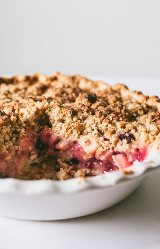 Closeup of cranapple pie with a slice taken out of it.