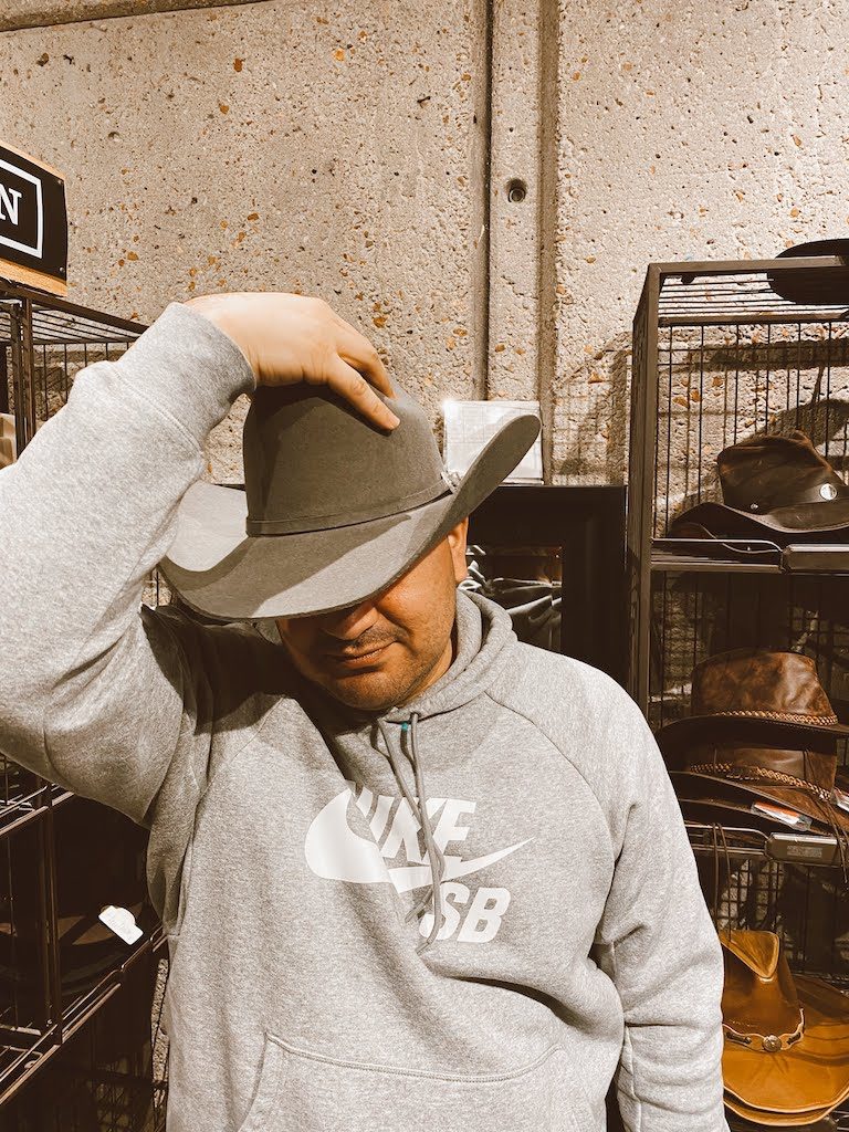 Daniel trying on a stetson hat.