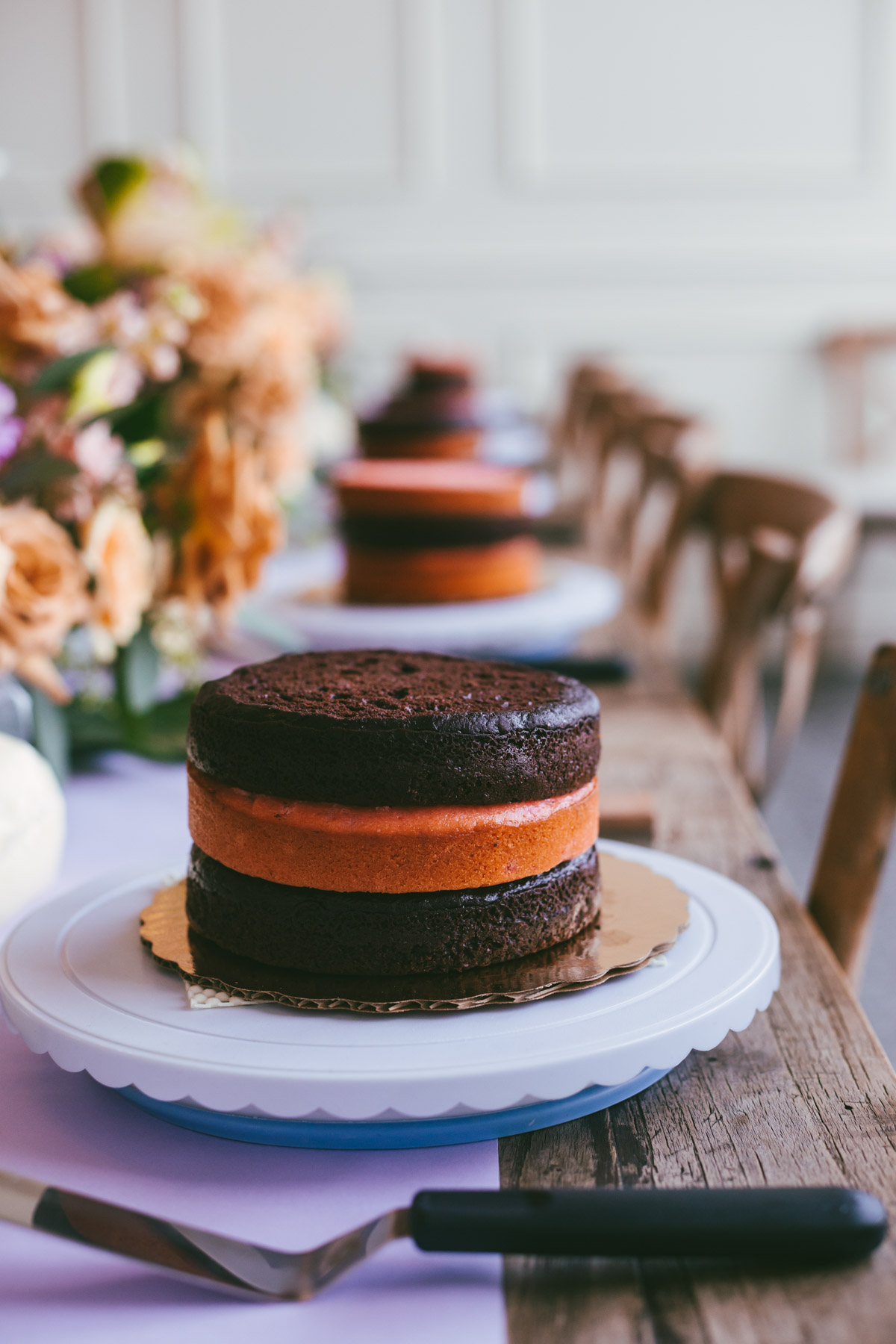 long table with flowers and cake layers ready to be decorated