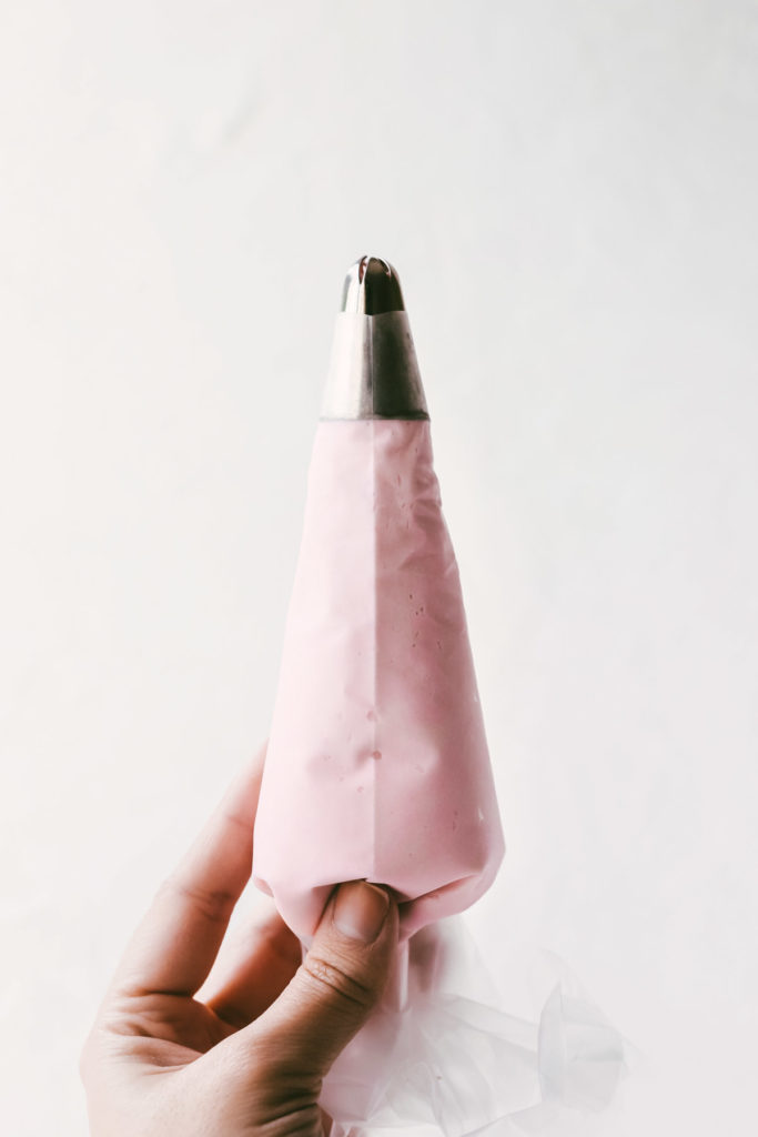 Piping bag filled with pink buttercream