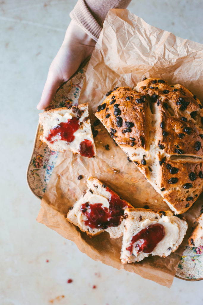 Hands holding a floral trey with sliced Irish Soda Bread