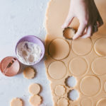 Sugar cookie dough being stamped out by different sized circle cut outs