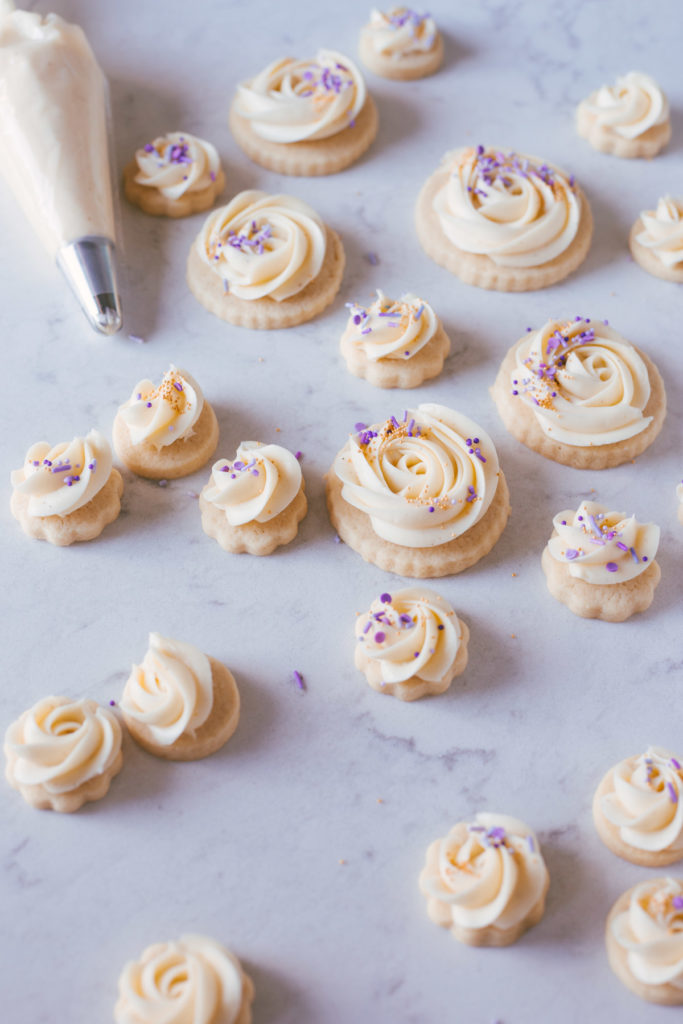 Finished cookies with buttercream swirled on the tops and purple sprinkles