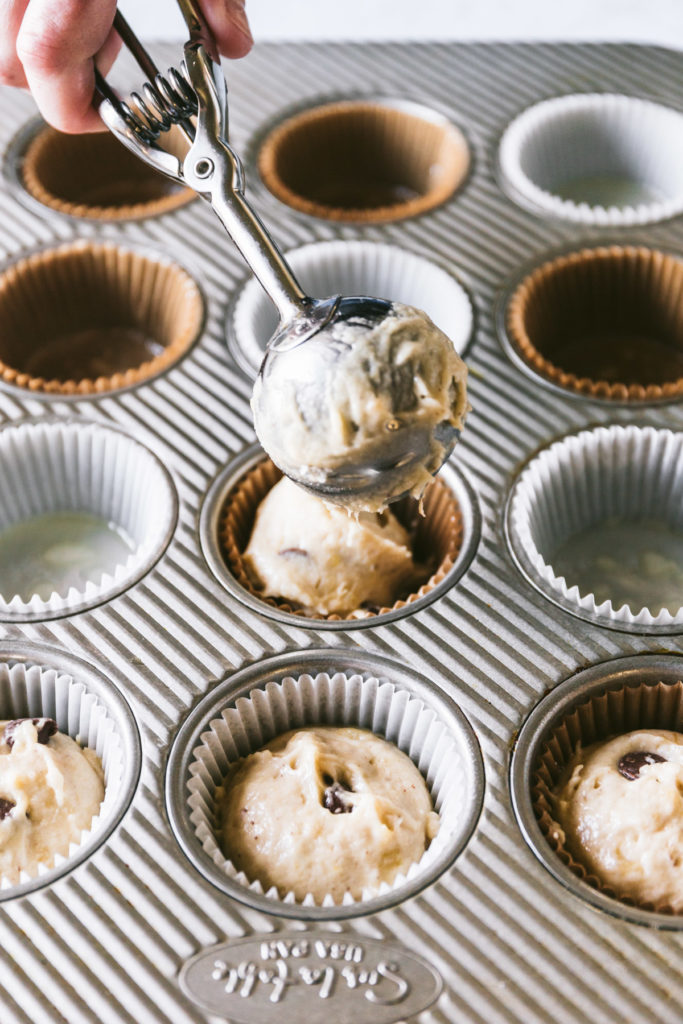 Muffin batter being scooped into muffin tin