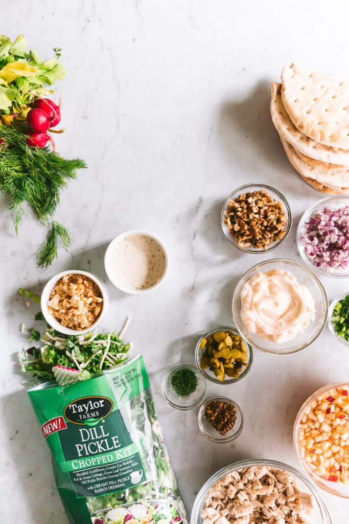 As the ingredients for Dill Chicken Salad Pitas in prep bowls