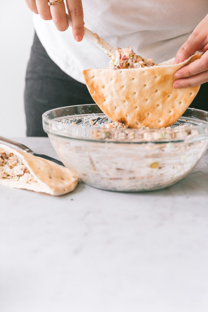 head on shot of chicken salad being stuffed into pitas