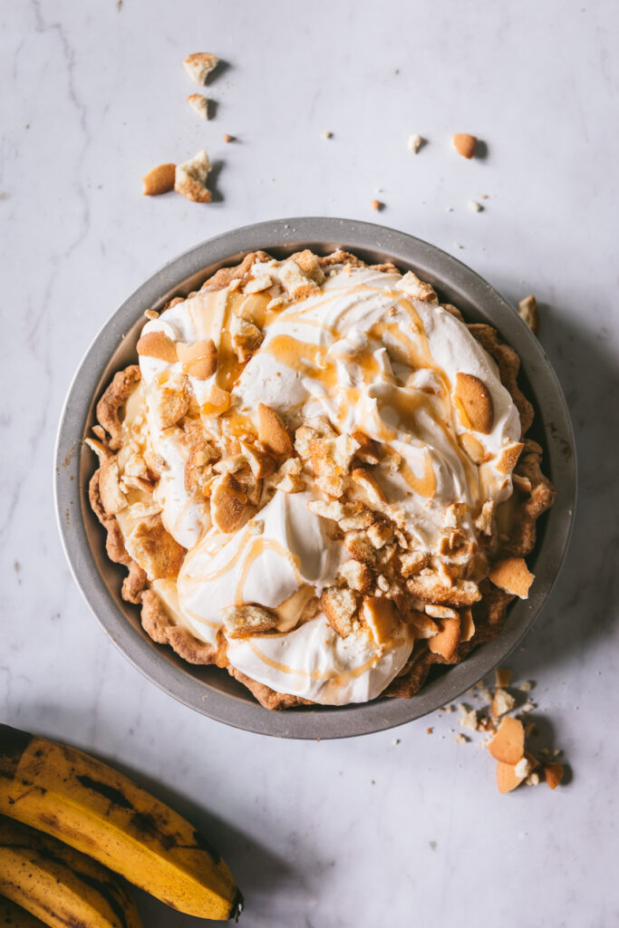 Overhead shot of full pie with soft whipped cream, caramel drizzle and crushed nilla wafers 
