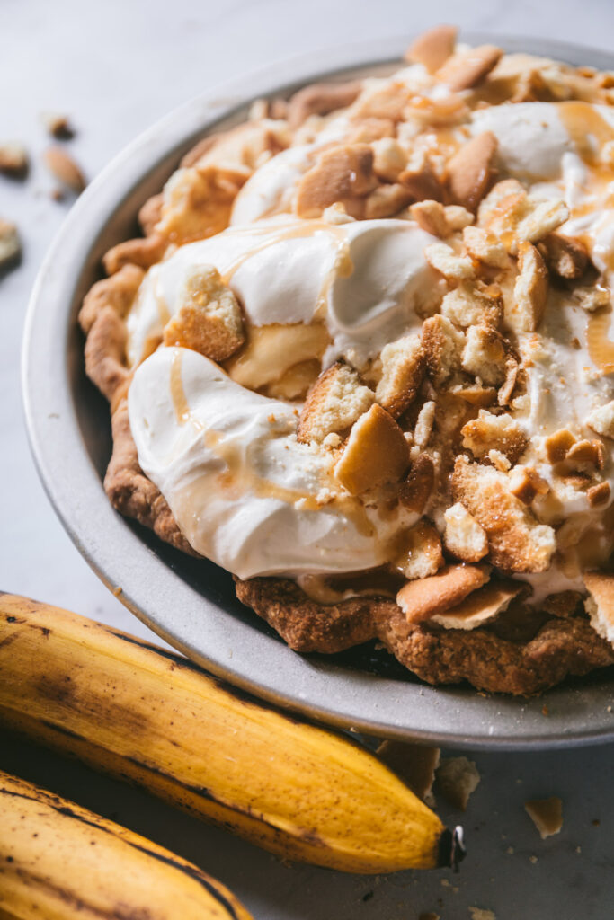 head on shot of full pie with soft whipped cream, caramel drizzle and crushed nilla wafers