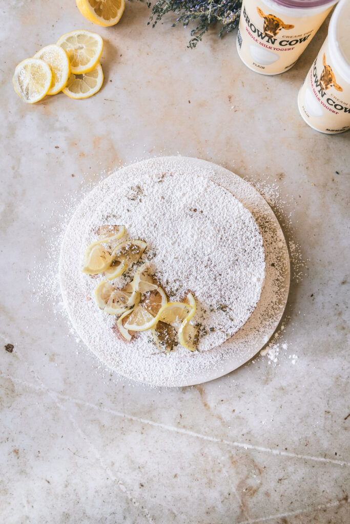 Overhead image of the finished cake with powdered sugar and lemon slices for detail