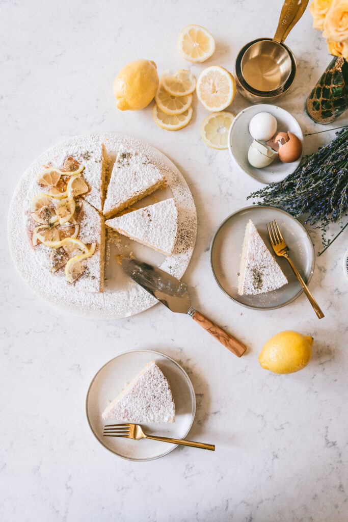 Overhead image of the Head on angle of cake with a slice slightly moved away from the cake with two cake plates filled with cake