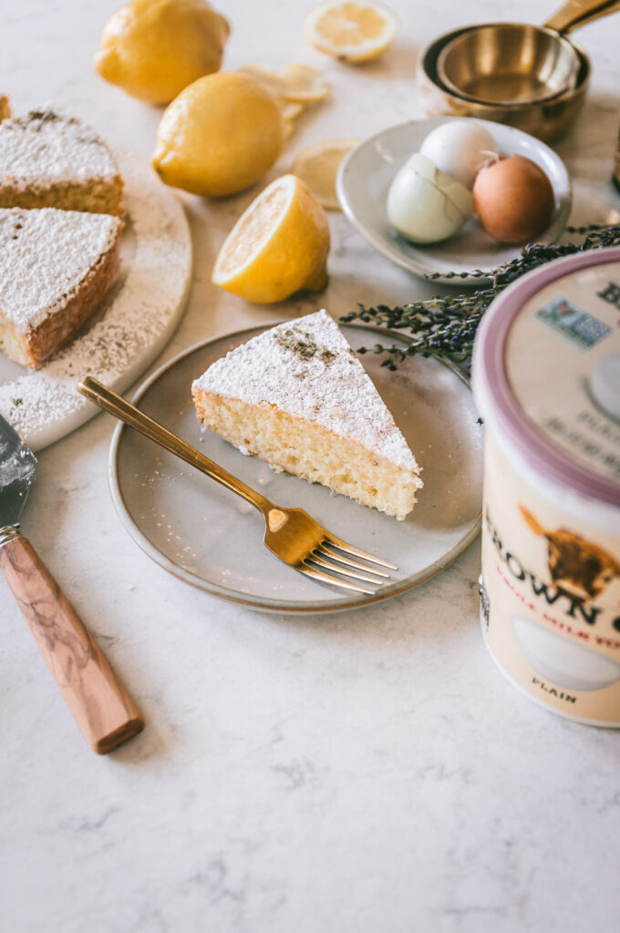 A close up image of one slice of cake with props surrounding.