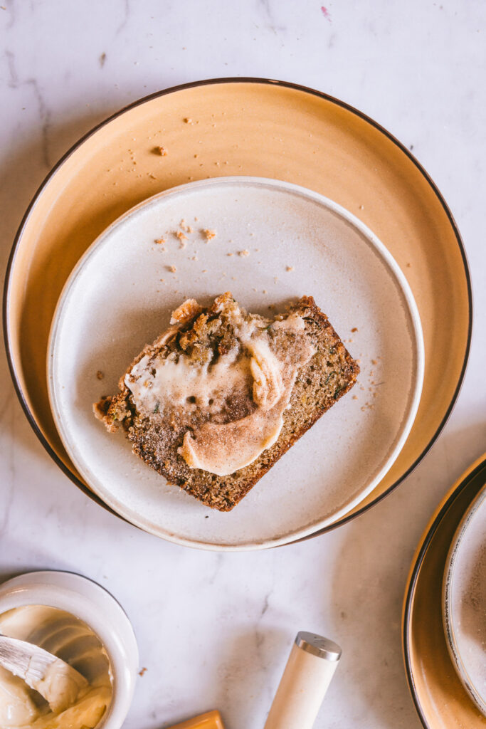 zucchini bread slice on a plate, buttered and sugared