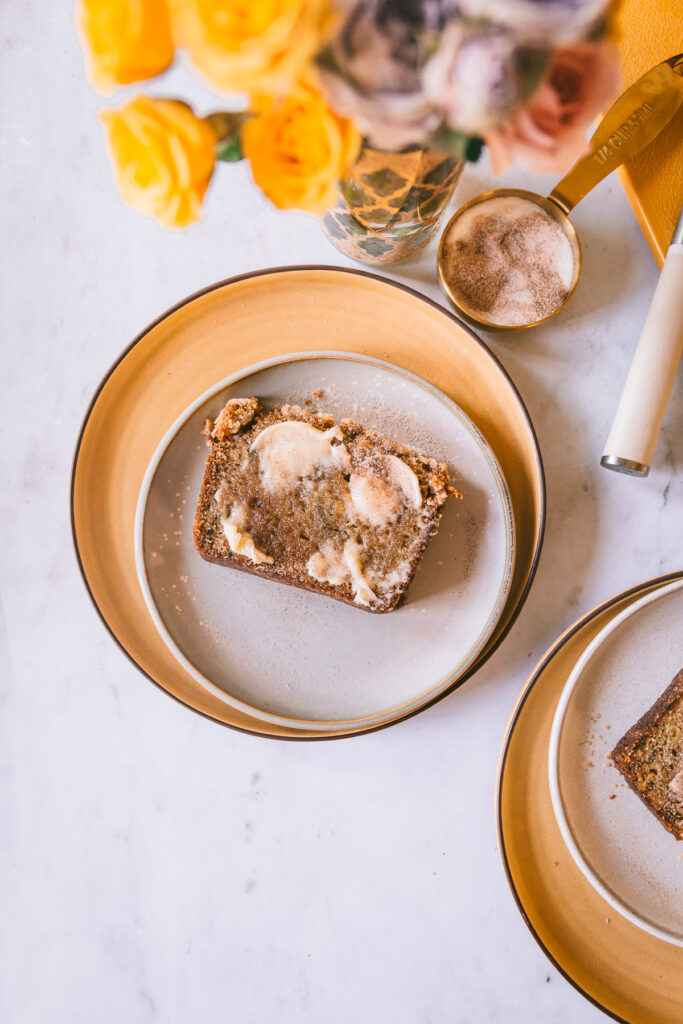 zucchini bread slice on a plate, buttered and sugared