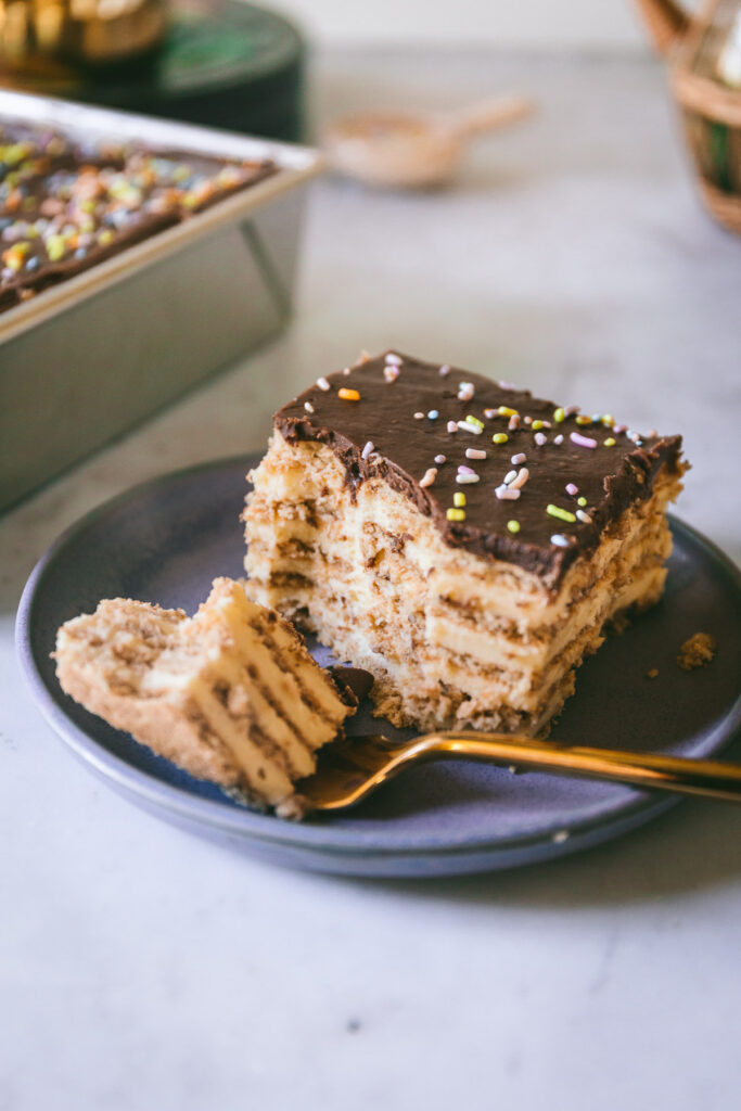 a slice of icebox cake on a purple plate with a bite taken out.