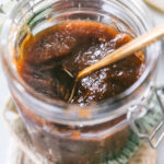 Close look at the peach butter in the jar with a spoon in it