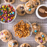 Overhead image of Kitchen Sink Cookies on a cooling rack with honey, pretzels, m&ms