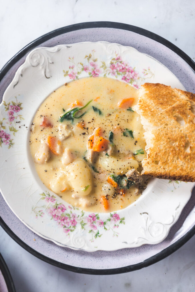 Ovehead shot of Creamy Chicken Gnocchi Soup with crusty bread