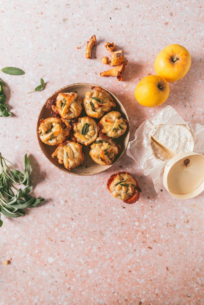 Overhead shot of a bowl of Apple Chanterelle Brie Stuffed Pastry with ingredients scattered to the sides