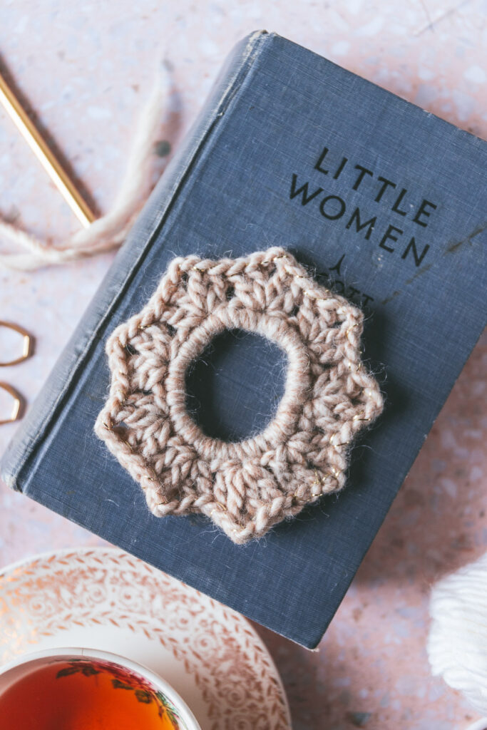 a single knit scrunchie on top of the book "Little Women"