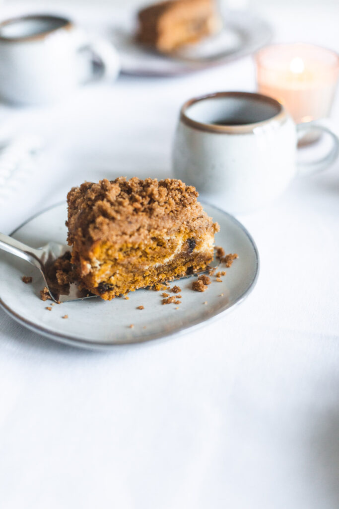 A slice of Chocolate Chip Pumpkin Coffee Cake with Cream Cheese Filling revealing the inside