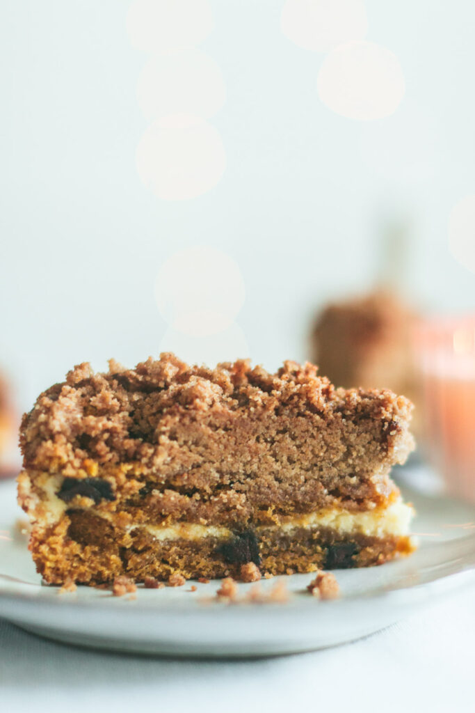 A slice of Chocolate Chip Pumpkin Coffee Cake with Cream Cheese Filling revealing the inside